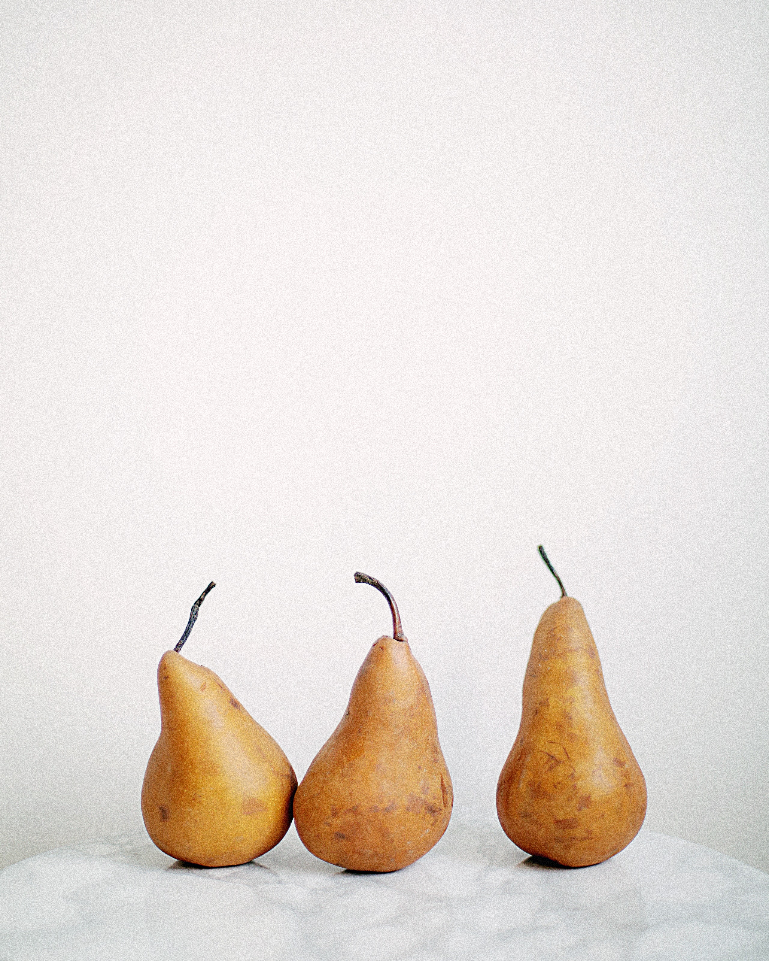 three-brown-fruits-on-white-textile-800356